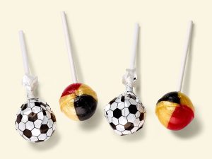 4 Küfa football lollies (ball shaped lollipops), of which 2 with wrapper (printed black and white football design) and two without wrapper, So you can see the colors of the lolly black, red and gold.