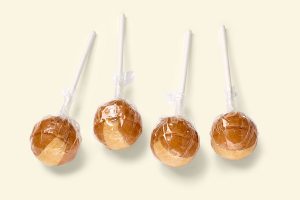 Küfa Cream-Lolly with Nougat-Filling (hazelnut cream), brown ball-shaped cream lollipops with beige stripe, with nougat filling