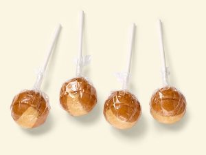 Küfa Cream-Lolly with Nougat-Filling (hazelnut cream), brown ball-shaped cream lollipops with beige stripe, with nougat filling