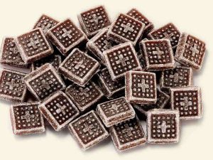 Küfa Herbs-Salmiak-Sweets (square, flat, brown candies with cross embossing with herbal extract)